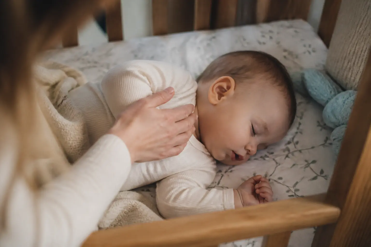 Bebe qui ronfle dans son lit, parent vérifiant doucement sa respiration, ambiance nuit rassurante et inquiète